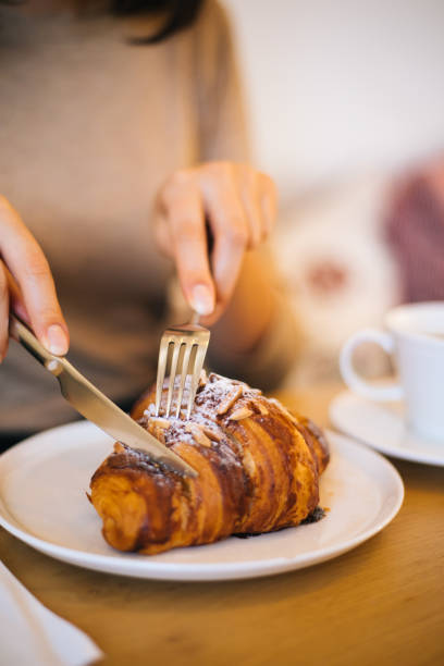 Woman eating croissant