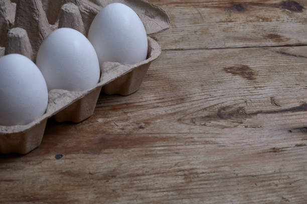istock Eggs in the container at weathered wooden background copy space 1200706610