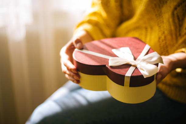 istock Young woman holding valentine day gift box 1200707166