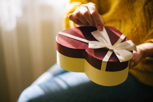 istock Young woman holding valentine day gift box 1200707286