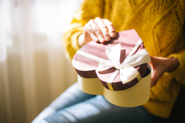 istock Young woman holding valentine day gift box 1200707293
