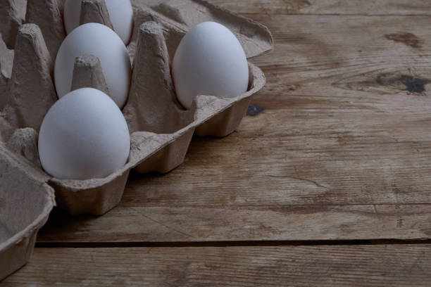 istock Eggs in the container at weathered wooden background copy space 1200707324