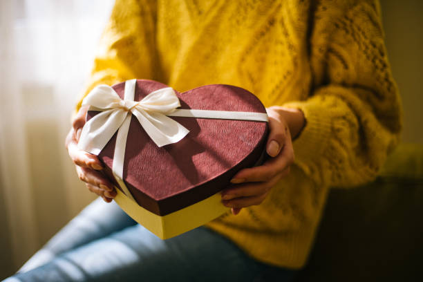 istock Young woman holding valentine day gift box 1200707401