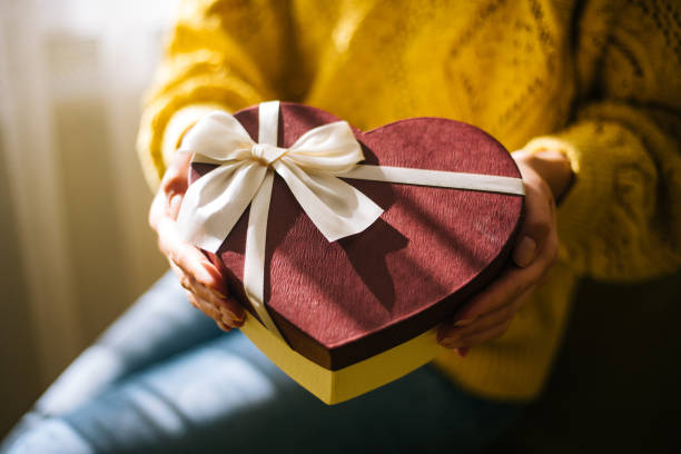 istock Young woman holding valentine day gift box 1200707438