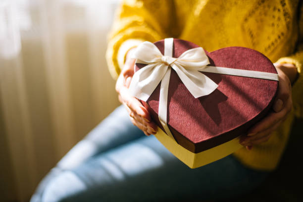istock Young woman holding valentine day gift box 1200707440