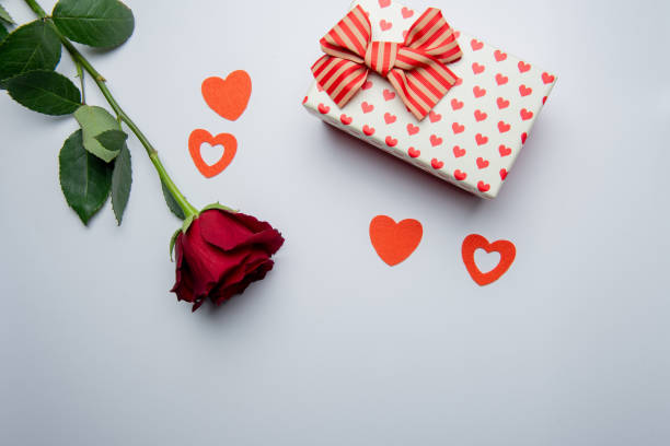 istock gift box with red hearts and rose on a white background 1200707478