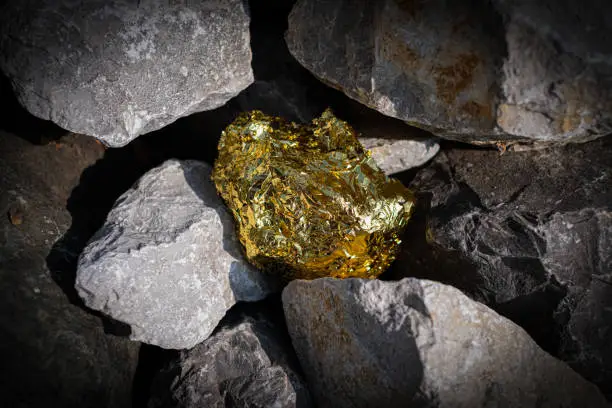 Gold nugget and grey granite stone background