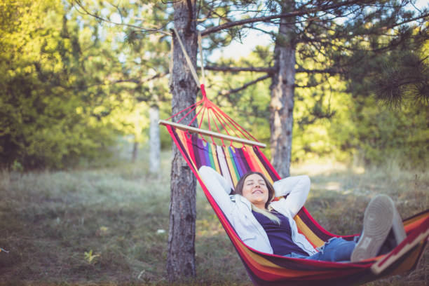 istock Young woman relaxing in a hammock 1200710429