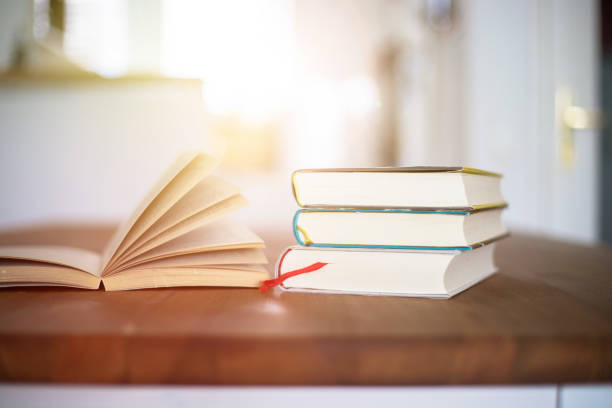 istock Knowledge and science concept: Stack of books lying on wooden desk, home. 1200712359