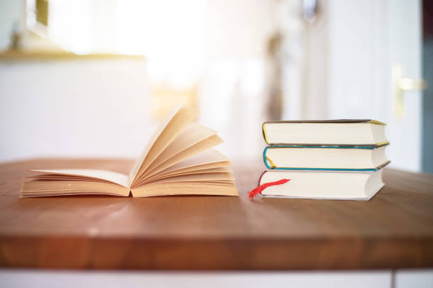 istock Knowledge and science concept: Stack of books lying on wooden desk, home. 1200713222