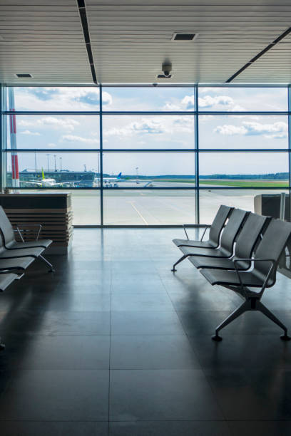 istock Empty chairs in airport terminal with view to airplanes. 1200714919