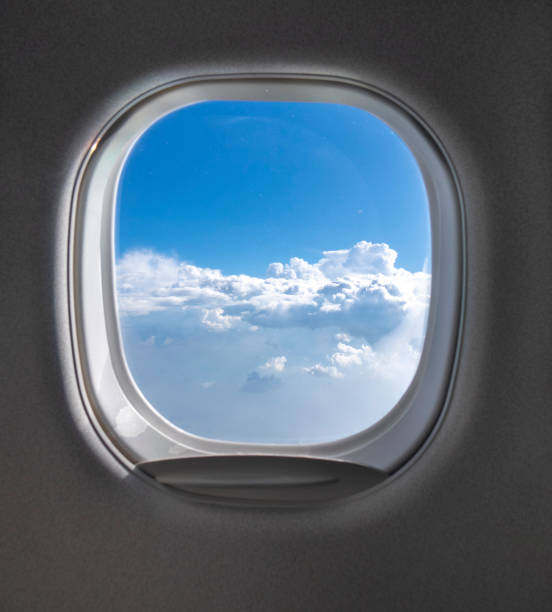 istock View of cloudy blue clear sky through airplane porthole. 1200714973