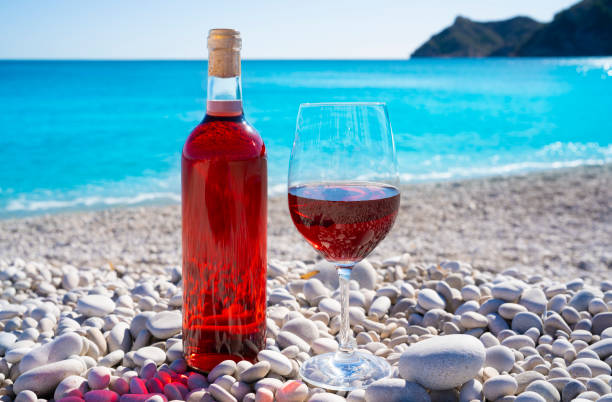 istock Red wine and wine glass on the beach 1200715667