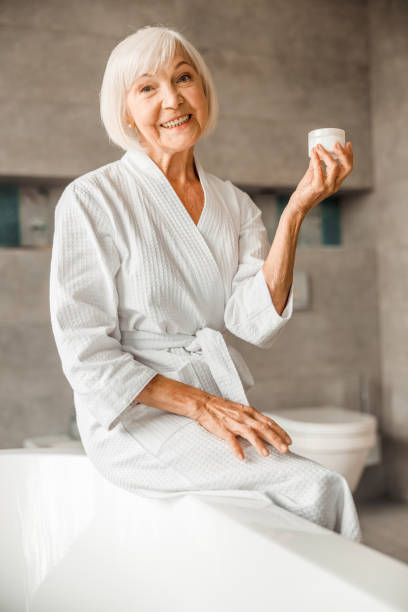 istock Cheerful elderly woman holding jar of cream 1200716632