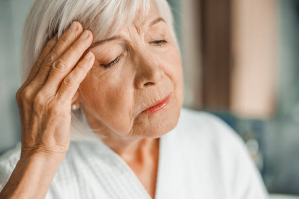 istock Unhappy elderly lady touching forehead and having headache 1200716660