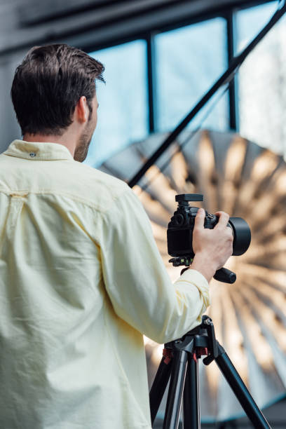 istock back view of photographer touching digital camera on tripod 1200716843