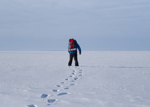 istock Lonely human walks throw snow field in tundra. 1200719424