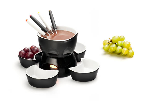 A delicious chocolate fondue, served on a caquelon over a small burner. Long-stemmed forks are used to put the grapes into a warm and melted chocolate.
