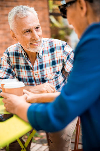 istock Joyful elderly man talking with lady in outdoor cafe 1200723855