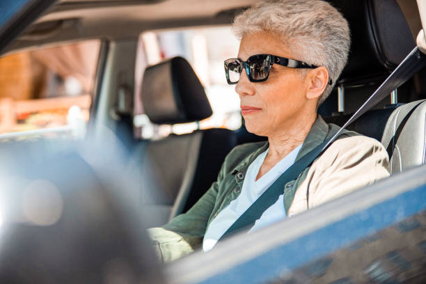 istock Elderly lady in sunglasses sitting in auto 1200724499