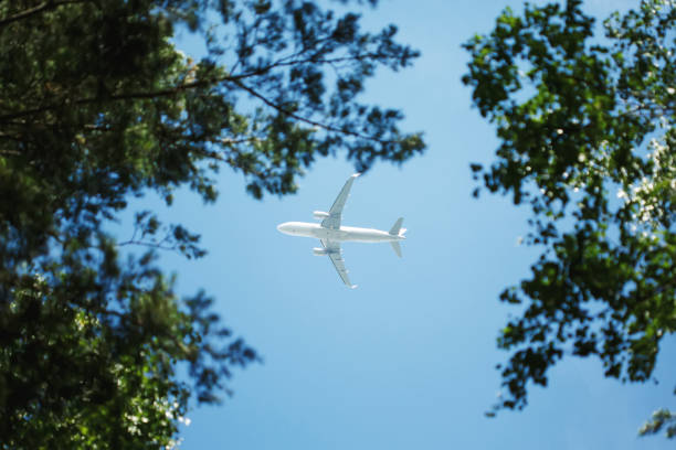 istock Bottom view on jet airplane flying in the sky overhead 1200724910