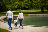 Young couple walking with their son by the lake in old European town
