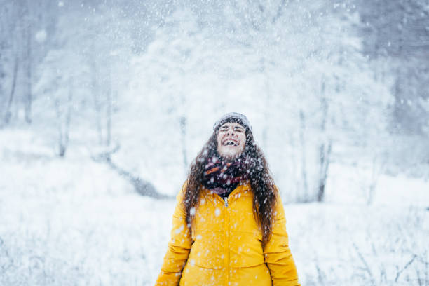 istock Girl in down jacket throws snow up in the winter forest. 1200725276