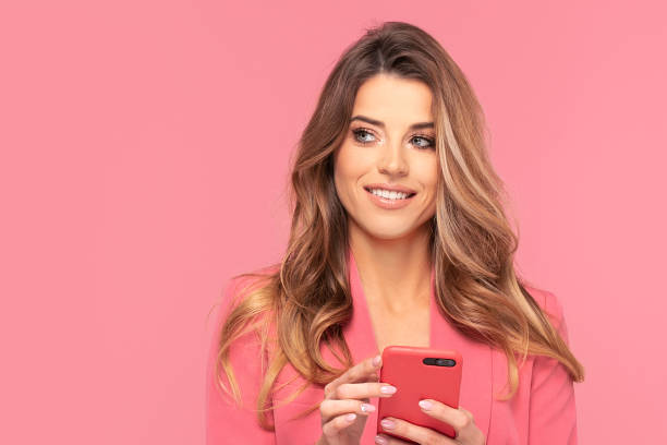 istock Smiling Young Woman Using Mobile Phone. 1200725616