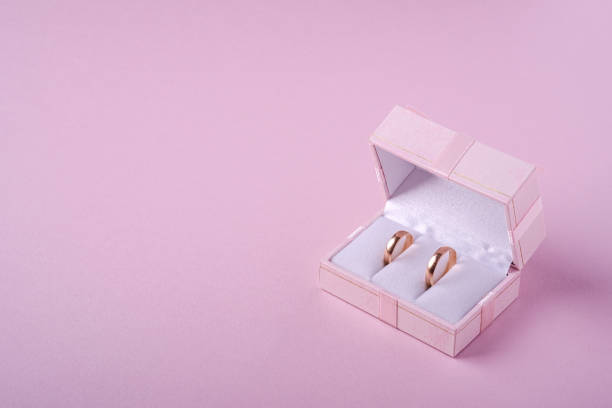 istock Wedding gold rings in pink gift box on soft pink background, angle view, copy space 1200727068