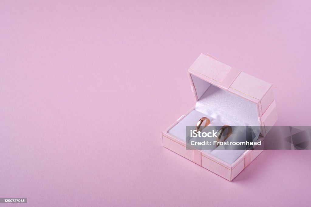 Wedding gold rings in pink gift box on soft pink background, angle view, copy space Wedding Ring Stock Photo