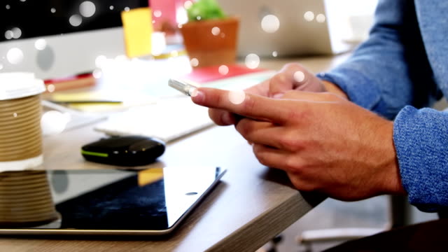 Close-up of hands men writing on his mobile phone leaning on desk