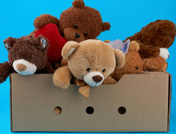istock brown cardboard box with various teddy bears, blue background 1200728520