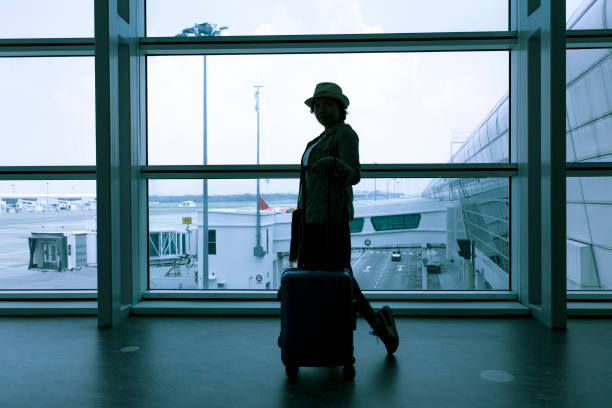 istock a woman with baggage on moving walkway 1200728750