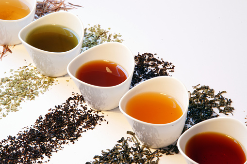 Selección de té colorido - diferentes tipos de té suelto en tazas pequeñas photo