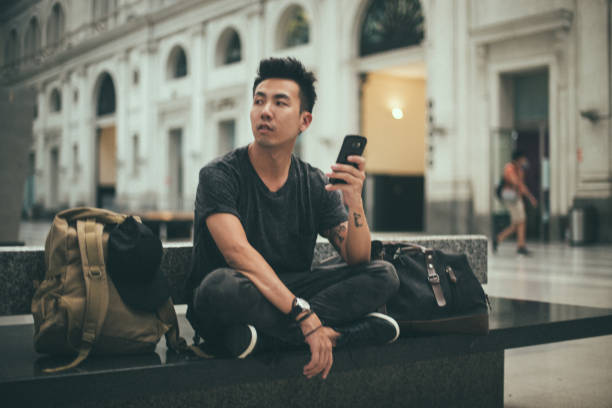 istock Hipster man sitting on the train station 1200732748
