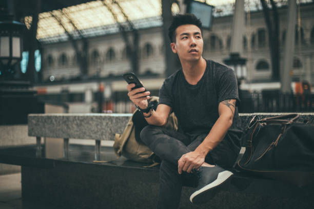 istock One hipster man sitting on the train station 1200732792
