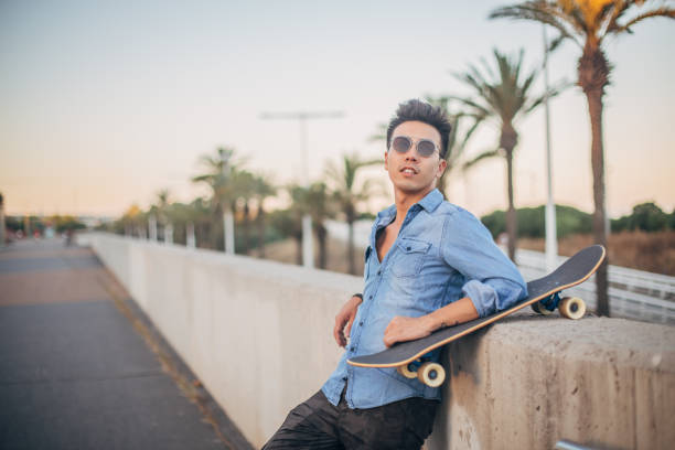 istock Handsome man with skateboard on the street 1200733028