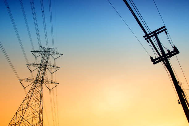 istock High-voltage tower at sky background,high voltage post at sky backgound, Silhouette of pylons,Electricity pylons and lines 1200733884
