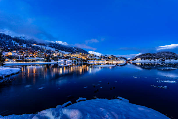 vista das belas luzes noturnas da cidade de st. moritz, na suíça, à noite no inverno, com reflexão do lago e montanhas de neve em backgrouind - mountain night switzerland engadine - fotografias e filmes do acervo