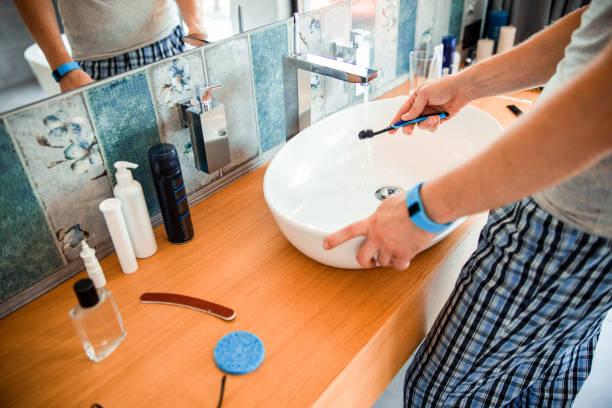 giovane che ha intenzione di lavarsi i denti in bagno - water lime foto e immagini stock