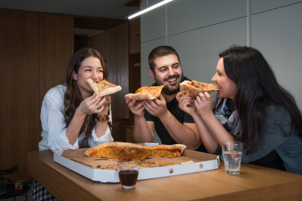 istock Young happy friends having fun while eating pizza at home 1200739628