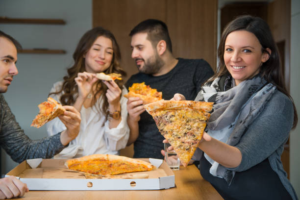 istock Beautiful girl offering pizza piece 1200739871