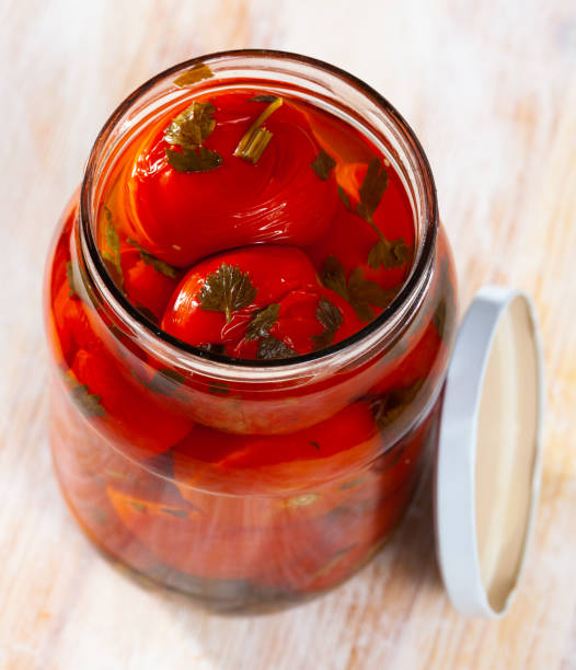 istock Tomatoes marinated in jars on a wooden table 1200740208