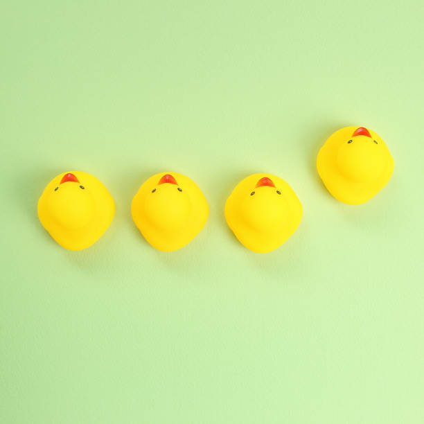 istock Yellow rubber duck doll on green background 1200741974
