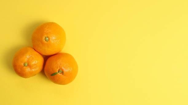 istock Fresh Tangerine Fruit on yellow background 1200742140