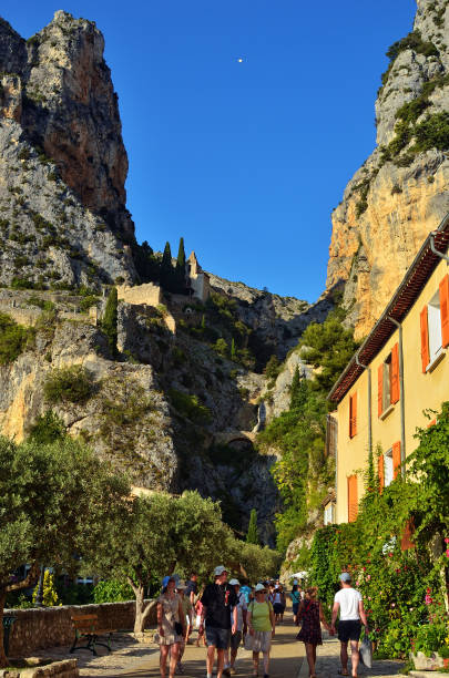 Saint Mary's Musketeers MOUSTIERS SAINTE-MARIE, FRANCE - JUL 18, 2014: Tourists on the narrow street of the beautiful medieval village. Moustiers Sainte Marie village is included in list of "The most beautiful villages of France" sainte marie stock pictures, royalty-free photos & images