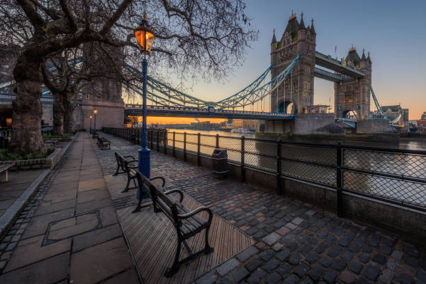 tower bridge with bench and street lamp foreground during sunrise, london, uk - london england morning sunlight tower bridge imagens e fotografias de stock