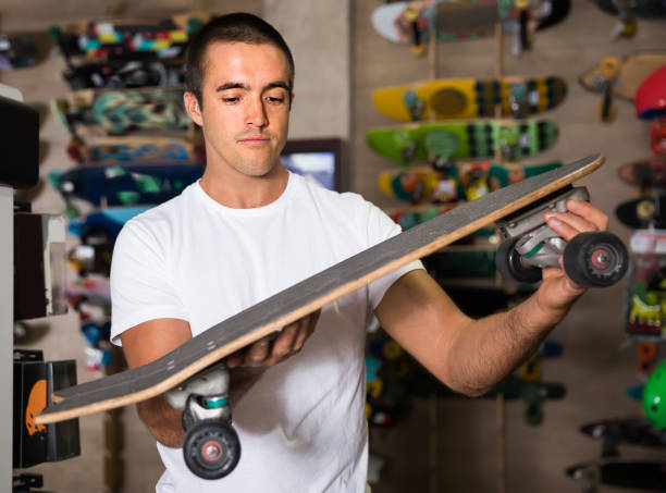 istock Portrait of glad man choosing new skateboard 1200744975
