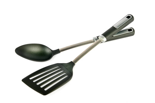 Metal Kitchen spoon and spatula on isolated white background.