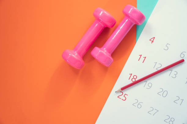 istock Time for exercising calendar and dumbbell with colorful background on the table 1200746737